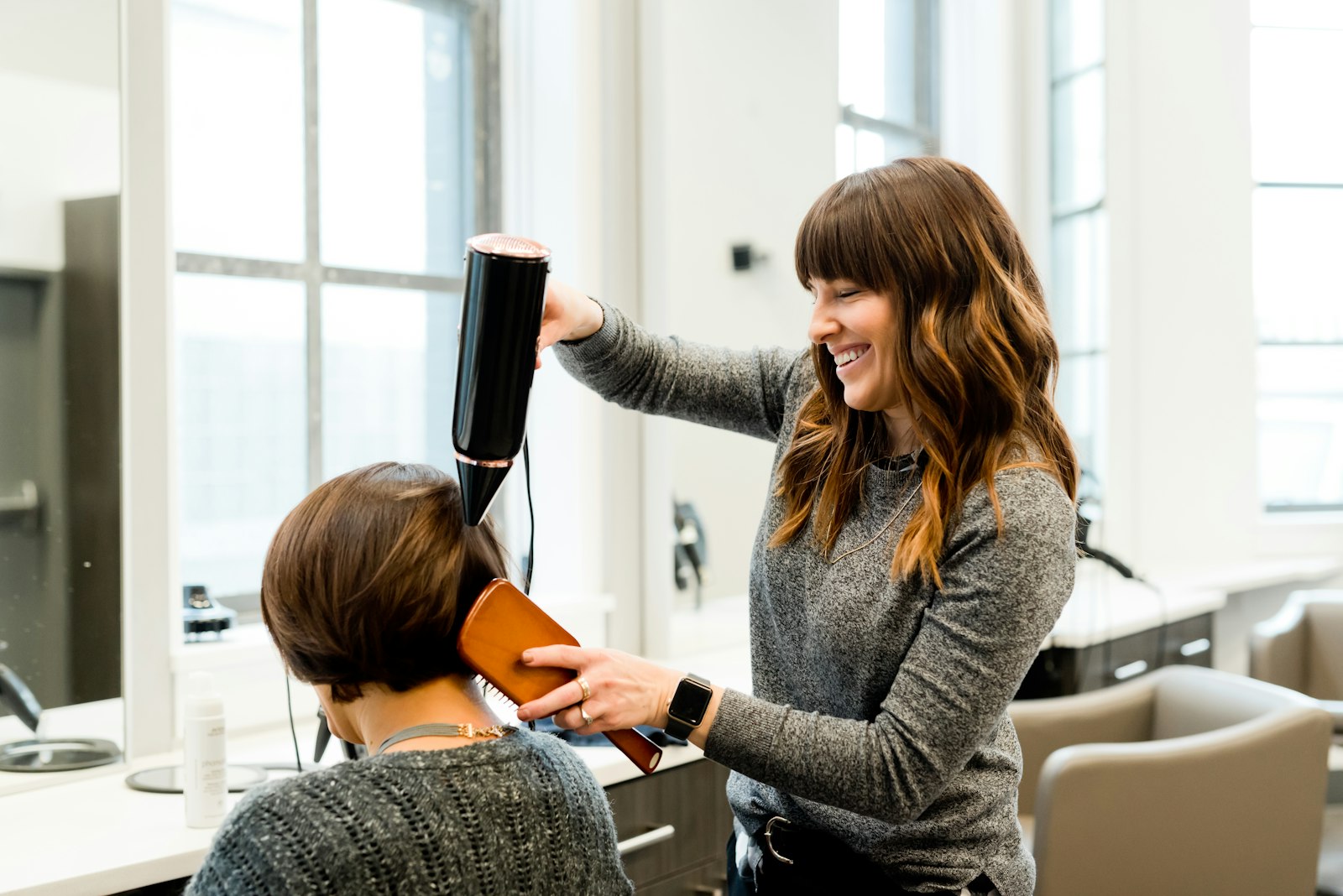 Estilista secando el pelo de una clienta
